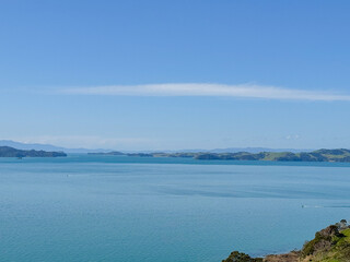 View of a park in New Zealand. Blue ocean and green grass field on spring day. Duder Park.