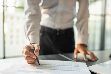 Close up of businessman hands signing or writing document paperwork and report Auditor analysis male professional hand making notes with Business Document.