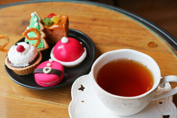 Cup of Hot Tea with Blurry Christmas Afternoon Tea Pastries in the Backdrop