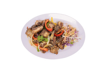 a plate of ribs with a colorful assortment of vegetables and garnishes, beautifully arranged on an oval white plate against a white background.