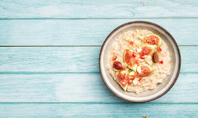 Oatmeal with figs, nuts and pomegranate, top view, copy space