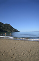 Looking out over the mediterranean from Iztuzu beach in Turkiye. Shallow sandy beach with mountainous headland.