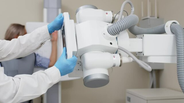 A specialist in the X-ray room prepares the equipment for a patient's radiography. Modern medical technologies ensure accurate diagnostics and safety during procedures.