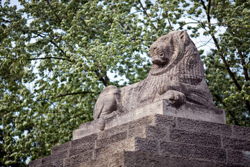 Stone Lion Statue at the Berlin Zoo Entrance Surrounded by Greenery