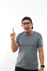 Fototapeta premium Asian man with beard wearing casual t-shirt and glasses over white background pointing finger up with successful idea. Excited and happy. Number one.