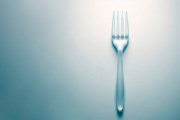 Plastic fork on a light background. Space for text.