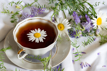Herbal tea, chamomile flowers and honey on rattan matting Close-up