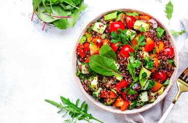 Quinoa vegan salad with avocado, tomatoes, onion and parsley, white background, top view