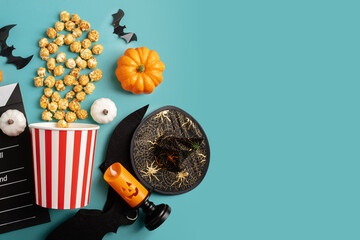 Halloween cinema, popcorn and movie clapperboard with halloween pumpkins on green background, movie night in the theater with grainy film and horror flicks