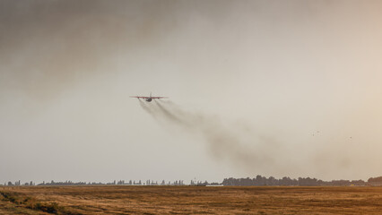 Turboprop airplane taking off at sunset. trail of smoke behind cargo aircraft during climb.