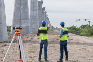 construction worker with helmet. Team surveyors  check  leveling of railway construction site.