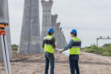 construction worker with helmet. Team surveyors  check  leveling of railway construction site.