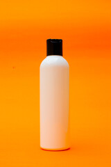 A mockup of a white plastic bottle with a black cap. This bottle is a body lotion bottle. 