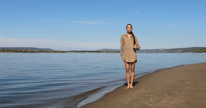 Photo posing - young beautiful girl shows correct poses for a photo on the beach
