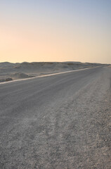 Empty desert road at sunset, front focus on asphalt, Egypt.