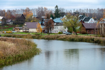 Obraz premium View of the Kamenka River and residential buildings on an autumn day. Suzdal, Vladimir region