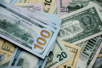 Big amount of US dollar bills in different nominations on table. Many dollar banknotes under natural light