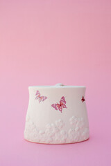 An artisan white container made of ceramic. This container can serve as a flower vase or to put other objects.