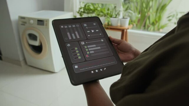 Cropped shot of anonymous housewife using digital tablet to control smart home system