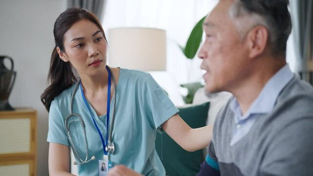 Young Asian female care nurse gives advice and listens to elderly man health problems.
