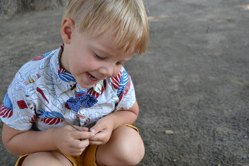 Blond boy 4 years old playing on a children playground and has fun. High quality photo.