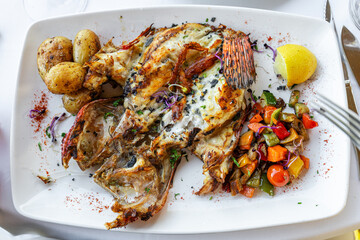Fischgericht mit Beilagen in einem Restaurant auf weißer Tischware 