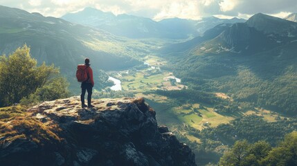 Obraz premium Flat lay of a hiker standing on a rocky mountain top, looking out over a vast valley filled with rolling hills and dense forests