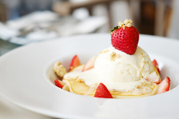 Homemade strawberry pancake with vanilla ice cream on white plate at cafe and bakery shop