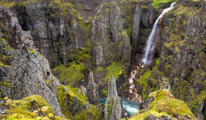 Waterfall with steep cliffs at Kolugljufur Canyon, Iceland
