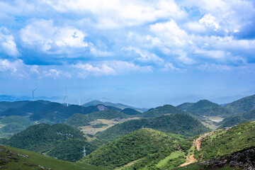 Wind turbines standing on the green prairie represent green environmental protection, sustainable development and protecting the earth