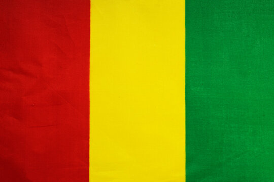 National flag of the state of Guinea close-up. State background.