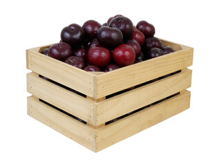 Ripe plums in wooden box isolated on white background