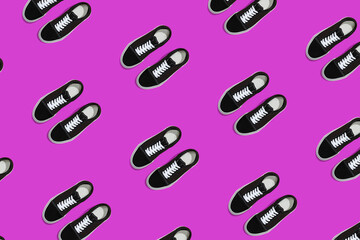 Pattern of black sneakers on bright purple background. Creative shoes concept