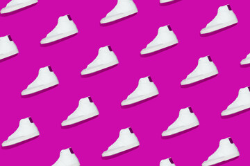 Obraz premium Pattern of white sneakers on bright purple background. Creative shoes concept
