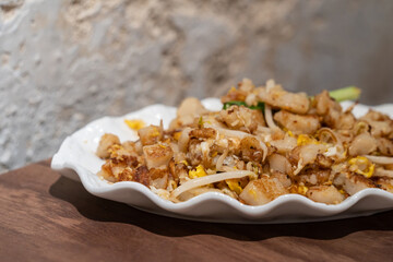 Close-up view of the fried carrot cake with egg, sprout and onion