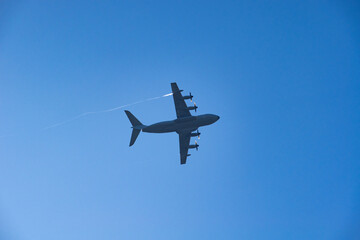 a military cargo plane flying low to drop paratroopers.