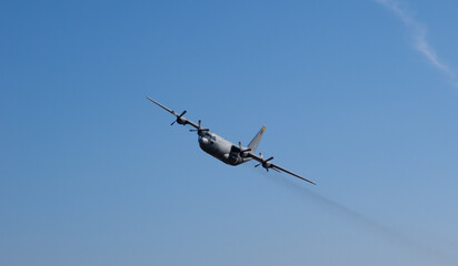 a military cargo plane flying low to drop paratroopers.