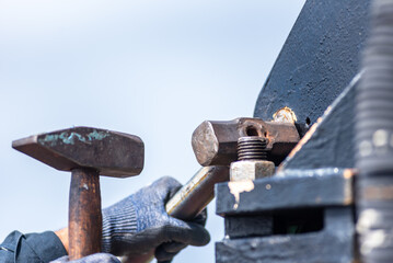 Strong hands clutch heavy hammers, caught mid-swing in the demanding task of knocking out a stubborn pin.