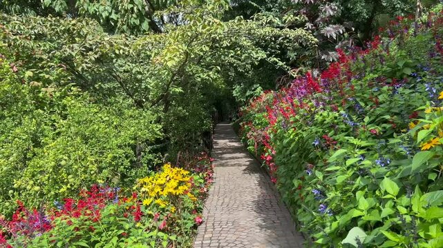 Sendero rodeado de flores en Merano,  Italia