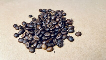 whole roasted coffee beans scattered on a beige background