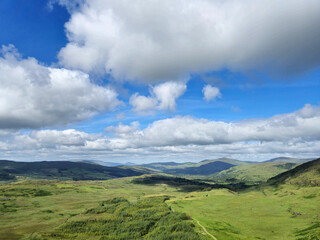 Green hills under blue summer sky landscape in Ireland