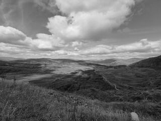 Green hills under blue summer sky landscape in Ireland, black and white monochrome grayscale photo
