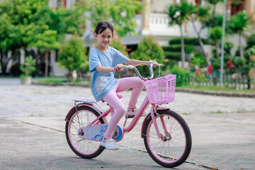 little asian girl riding bike outdoors