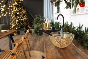 Close-up of a stylish bowl with a whisk on a wooden kitchen table. Stylish Christmas decorations in the dining room at home.