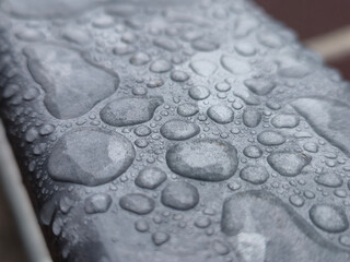 Water drops on a metal surface close view, raindrops on a fence