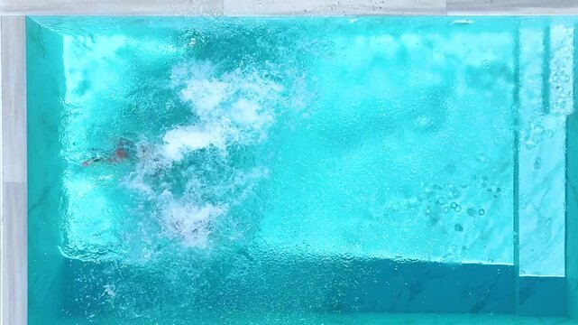 Aerial top view of a happy family jumping together in the pool as a summer travel concept with copy space