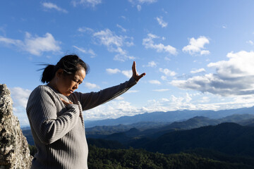 Woman praying and worshiping God on the mountain for a good life.