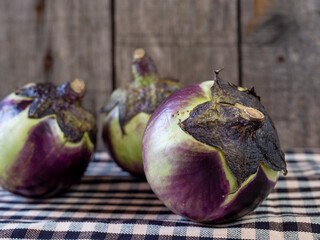 berenjena redonda o berenjena de florencia. Melanzana di firenze sobre fondo r&uacute;stico