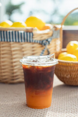Orange and coffee cocktai in clear plastic cups to take home on a vintage wooden table...