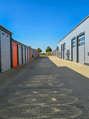 Naklejka premium street with storage or warehouse garages, blue sky